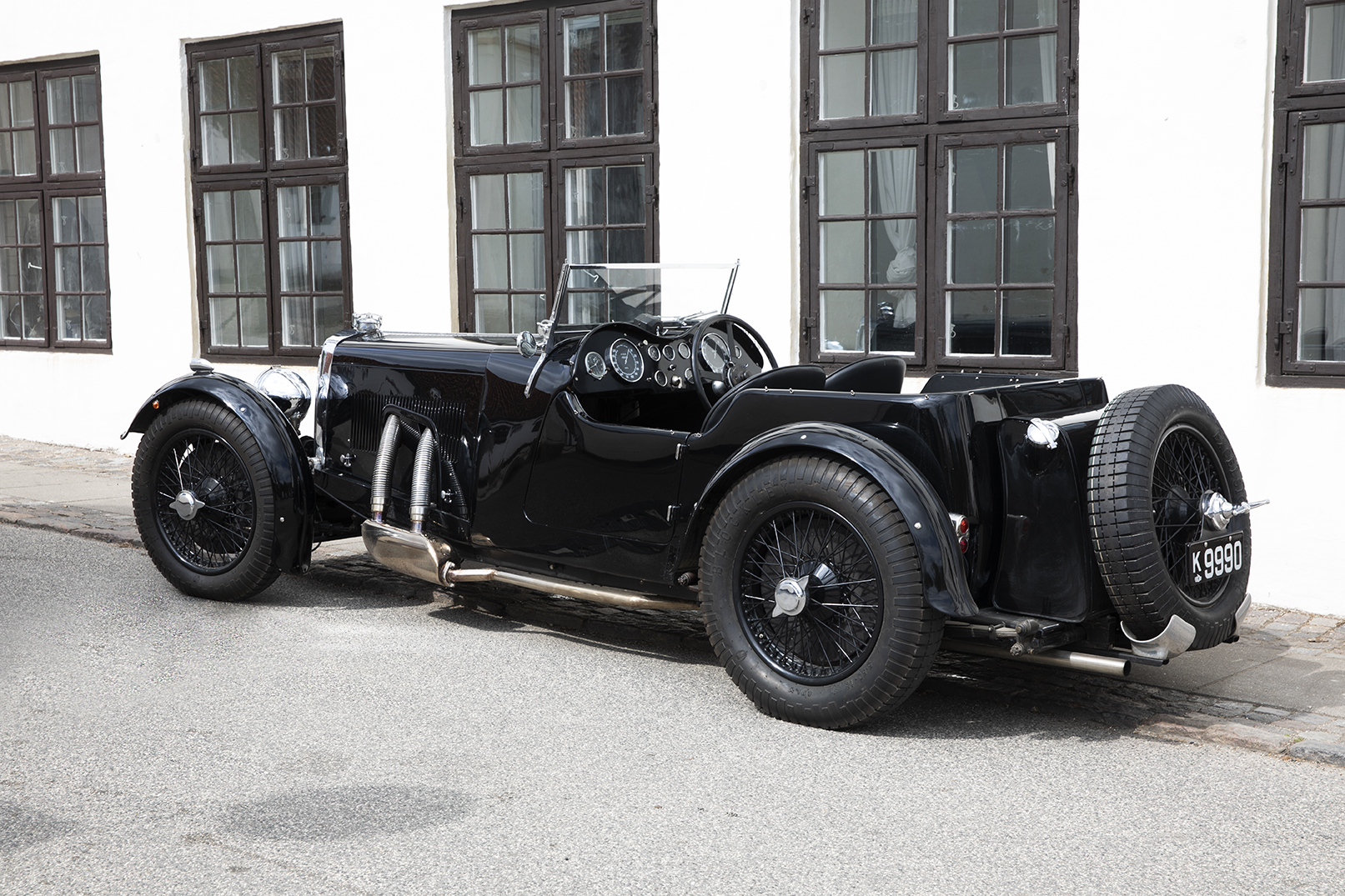 1933 Aston Martin Le Mans Short Chassis in front of an old house.